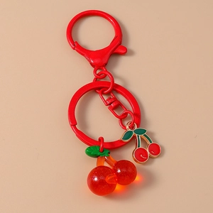 Detail of red cherry keychain featuring translucent resin and metal charms on red ring