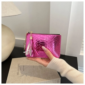 Macro detail of metallic pink snake texture coin purse with multi-color tassel zipper pull