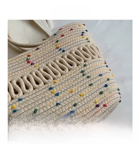 Detail of woven straw tote featuring wave hollow pattern and colorful dot accents
