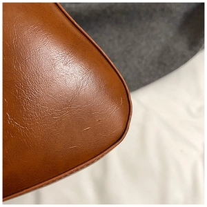 Close-up of the brown faux leather handbag showing smooth curved corners and fine texture