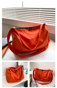 Detail view of large orange oxford tote bag showing waterproof fabric and zipper