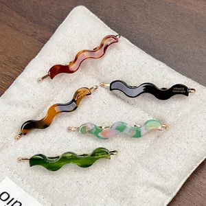 Five-piece wave acetate hair clip set in amber and marble patterns on linen bag