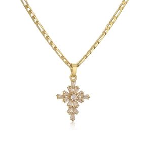 Macro shot of gold-plated cross pendant with clear cubic zirconia and Figaro chain