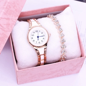 Close-up of golden quartz watch and gemstone bracelet set inside a pink gift box