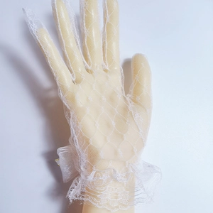 Close-up of white lace bridal glove with ruffled mesh and decorative ribbon bow detail