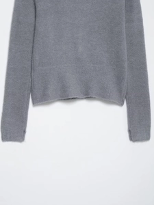 Dettaglio dei polsini e dell'orlo a coste di un cardigan in maglia grigio scuro