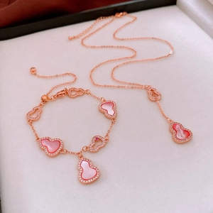 Detail of rose gold gourd jewelry set with pink shell inlay and micro-pave crystals