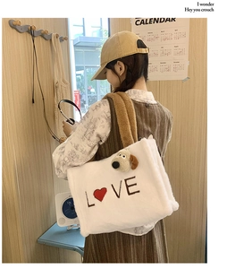 Detailed macro view of white plush tote bag with LOVE heart embroidery and dog charm