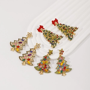 Macro detail of Christmas tree earrings with colorful crystals and pearls on white tray