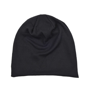 Detailed flat lay of black waffle knit texture on a stylish thermal beanie hat