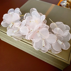 Gros plan de barrettes fleurs en tulle rose avec perles en cristal sur boîte verte