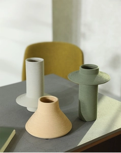 Detailed view of three ceramic vases with spiral texture in beige, green, and ochre colors