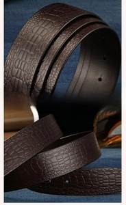 Detail of dark brown cowhide leather belt with premium crocodile embossed texture