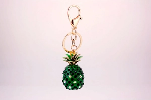 Close-up of pineapple keychain with green enamel leaves and colorful rhinestones