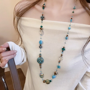 Detail of bohemian layered beaded necklace featuring turquoise and crystal stones