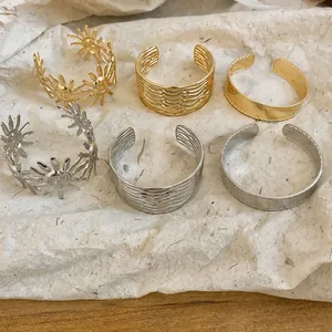 Set aus stilvollen offenen Metallarmreifen in Gold und Silber mit Texturen