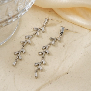 Close-up of silver tassel earrings featuring leaf-shaped design and step-cut cubic zirconia
