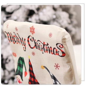 Détail de housse de chaise de Noël en lin beige avec motif de gnome et texte festif
