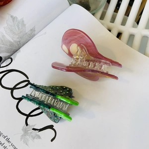 Detailed close-up of colorful resin hair claws with polished texture on a magazine