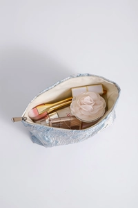 Interior view of light blue floral makeup bag showing brushes and cosmetics storage