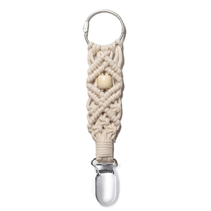 Detail of woven beige cotton hat clip with wooden bead and metal clasp for travel gear