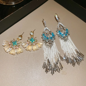 Macro detail of sparkling flower crystal fan earrings and silver needle tassels