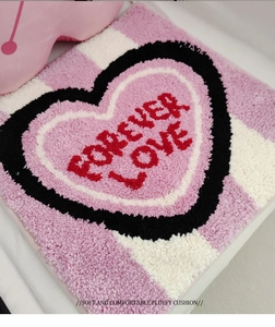 Macro shot of fluffy heart-shaped seat cushion with Forever Love text and plush texture