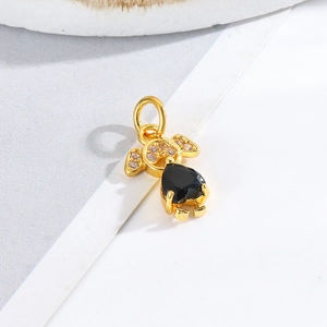 Macro shot of gold-plated boy and girl charm with heart-shaped black stone