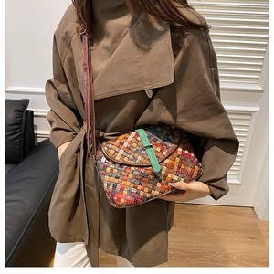 Gros plan du sac bandoulière tissé coloré avec carreaux de cuir et boucle verte