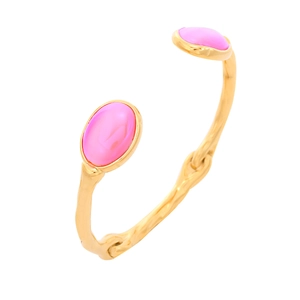 Detailed macro view of the open gold titanium steel bangle with pink oval gemstones