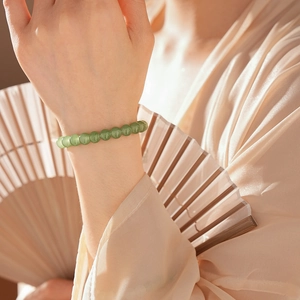 Close-up of elegant green chalcedony beaded bracelet worn with traditional outfit