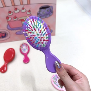 Close-up of portable purple massage hairbrush for children with colorful bristles