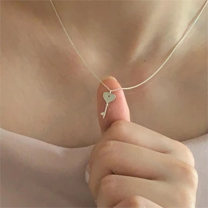 Close-up of 925 sterling silver heart key necklace on model to show the pendant size