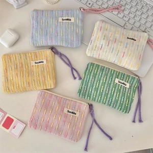 Detail der Strickstruktur von bunten Mini-Kosmetiktaschen mit gewebten Handgelenkschlaufen