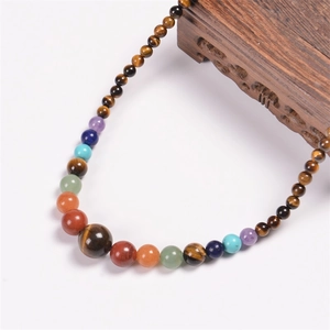 Detail of colorful 6mm natural stone beads on a Bohemian necklace with a vintage wood base