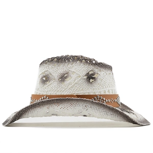 Détail d'un chapeau de cowboy en paille ajourée avec dégradé et bande en cuir clouté