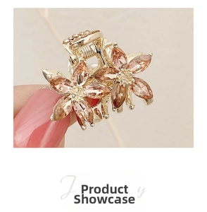Macro detail of golden flower hair claw clip with champagne crystal petals and fine beads