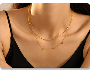 Details einer mehrlagigen goldenen Titanteilkette mit Sternanhänger und Schlangenkette