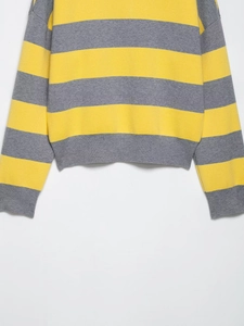 Détail d'un pull en maille rayé jaune et gris montrant l'ourlet côtelé et le tissu