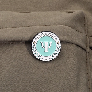 Detail of Psychologist logo metal badge with leaf patterns on brown fabric texture