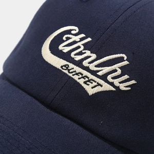 Detailed macro shot of 3D embroidery on navy cotton twill baseball cap fabric
