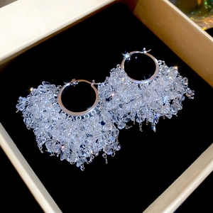Vue détaillée des boucles d'oreilles créoles avec pampilles en cristal sur velours noir