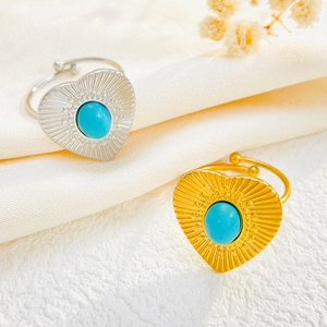 Macro detail of gold and silver heart-shaped rings with turquoise inlay on silk
