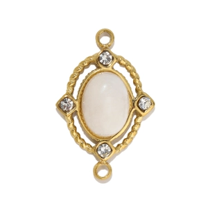 Detailed view of vintage gold oval pendant with white stone and four small zircon accents