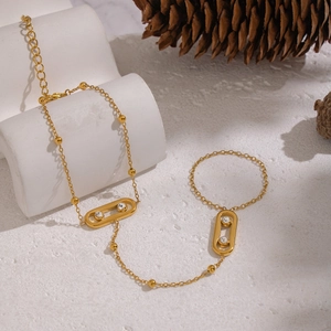 Bracelet bague en acier doré avec breloques ovales en zircon sur support en pierre