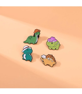 Detailed view of four colorful enamel dinosaur pins with cute hats on metal badges