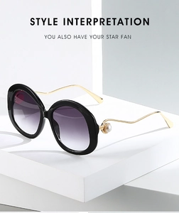 Detail of round vintage sunglasses with pearl-embellished temples and purple gradient lenses