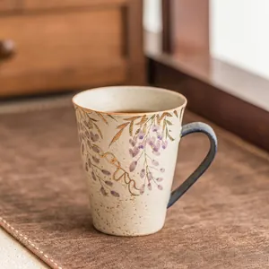 Détail macro de motif glycine et bordure dorée sur un mug en céramique artisanale