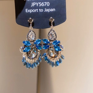 Detailed macro view of luxurious blue teardrop crystal earrings with silver setting