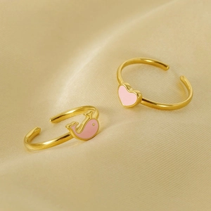 Detail of adjustable gold-plated rings with pink enamel heart and whale designs